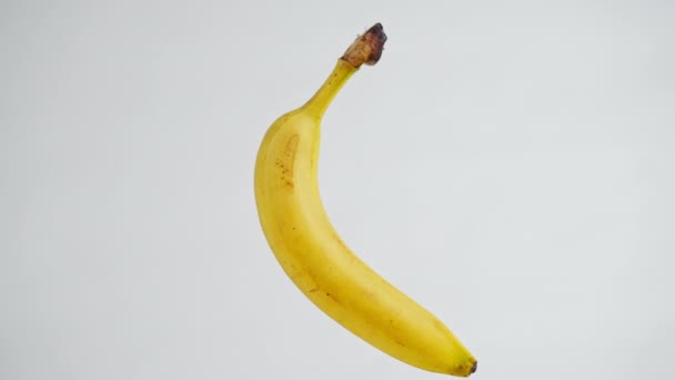 Plátano Amarillo Primer Plano Colgando Fondo Blanco Girando Cámara Lenta — Vídeos de Stock