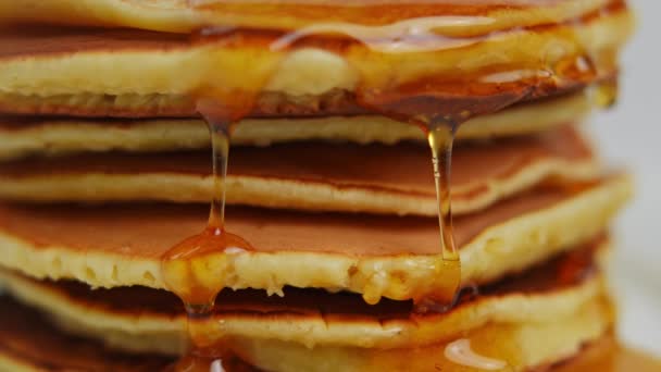特写甜甜的金黄色蜂蜜流淌在一堆煎饼上 在室内装扮美味的早午餐 — 图库视频影像