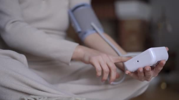 目に見えない妊娠中の女性を対象に 腹を撫でる装置で血圧を測定する近接血友病計 背景にぼやけた白人の若い期待を持つ右側のツール — ストック動画