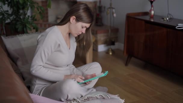 Skoncentrowana Biała Kobieta Ciąży Przewijająca Media Społecznościowe Cyfrowym Pastylce Szerokie — Wideo stockowe