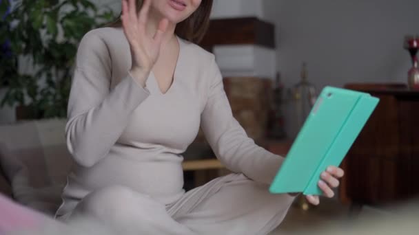 수없는 임신부 거실에 디지털 태블릿으로 비디오 채팅을 흔들어 행복해 있습니다 — 비디오