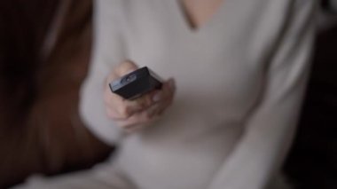 Televizyonda kanal değiştiren, tanınmayan hamile bir kadının uzaktan kumandası. Genç, rahat Kafkas beklentisi evde film izlemenin keyfini çıkarıyor.