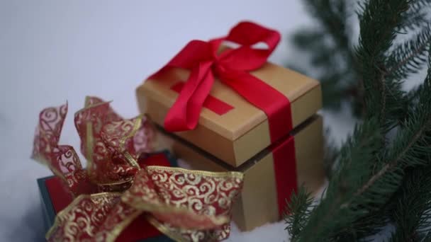 户外白雪上的特写圣诞礼物和常青冷杉树枝 头戴手套的女性手拿着一个新年礼物慢动作离开 — 图库视频影像