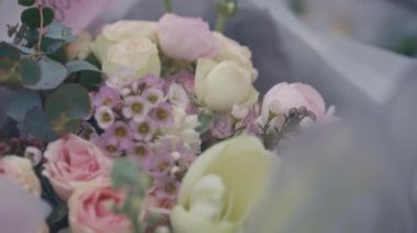 Canlı kamera pembe ve mor çiçekli buket boyunca hareket eder. Çiçekçide yakın plan dekoratif hediye.