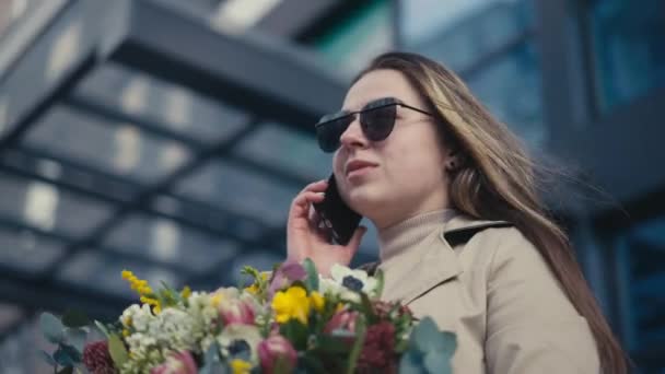 Een Jonge Vrouw Die Aan Telefoon Staat Met Bloemen Straat — Stockvideo
