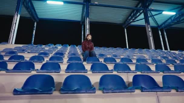 경기장 트리뷴에 심각한 운동장에서 코카서스 외로운 우울한 숙녀의 초상화 — 비디오