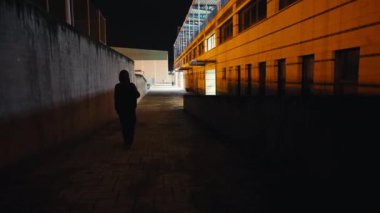 Arka plan geniş açılı kadın silueti gece caddesinde geziniyor. Şehir merkezinde yalnız yürüyen yalnız bir kadın.