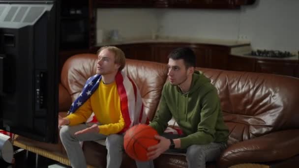 Faceci Piłką Koszykówki Flagą Usa Oglądają Mecz Sportowy Stojąco Radujący — Wideo stockowe