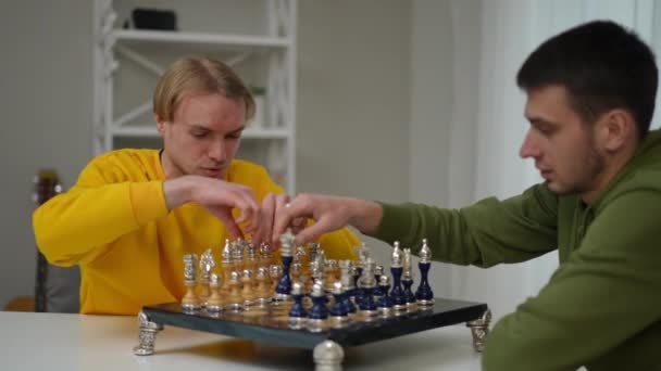 Mladí Muži Pokládají Šachové Figurky Palubu Sedí Stolu Obývacím Pokoji — Stock video