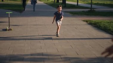 Heyecanlı çocuğun mutlu bir kadına koşarken, çocuğuyla parkta dönerken çekilmiş görüntüsü. Geniş açı Kafkas anne ve oğlu gün batımında eğleniyor.