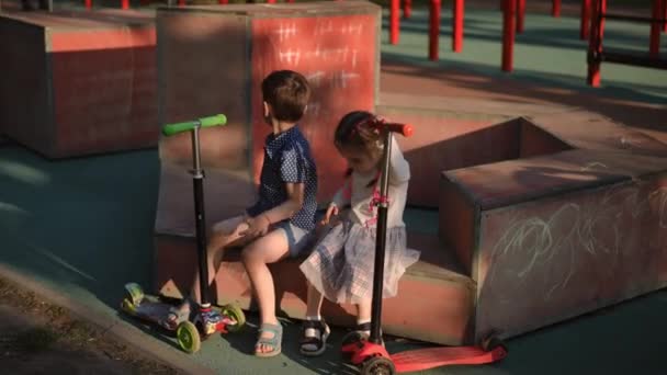 Miúdo Descontraído Com Scooters Sentados Parque Infantil Livre Alto Ângulo — Vídeo de Stock