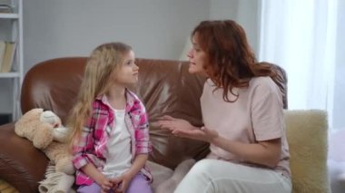 Tatminsiz bir anne, itaatsiz kızına bağırıyor oturma odasında kanepede el ele tutuşurken. Tatmin olmamış Kafkasyalı kadın evde azarlayan kız hakkında konuşuyor.