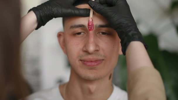 Orta Doğulu Genç Bir Adamın Güzellik Merkezindeki Yüzü Kaşlarının Arasında — Stok video