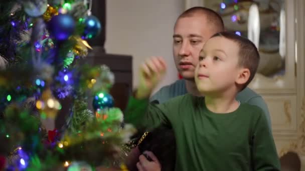 아버지와 아들은 벽난로에 바닥에 크리스마스 파티를 크리스마스 트리를 장식합니다 남자와 — 비디오