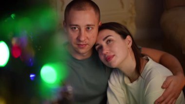 Ağır çekim. Birbirine aşık bir çift Noel ağacının manzarasından hoşlanır.