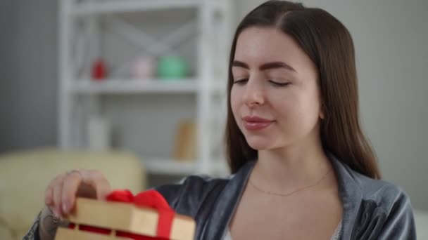 女孩手里拿着一个漂亮的木制礼品盒 盒子上系着一条红丝带 女孩打开盒子 看到了礼物 高兴地微笑着 — 图库视频影像