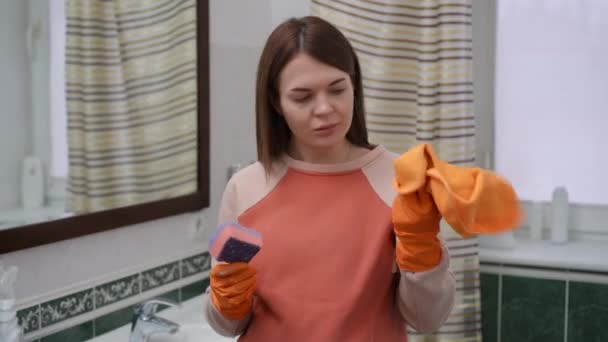 Eine Frau Mit Gummihandschuhen Steht Badezimmer Und Betrachtet Ihre Hände — Stockvideo