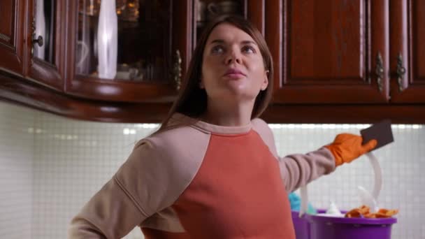 클로즈업 여자는 주위를보고 현대적인 가정의 부엌에 서있는 여자는 장갑에 그녀의 — 비디오