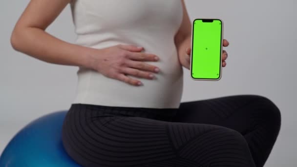 Detailní Záběr Nerozpoznatelná Těhotná Žena Sedí Bílém Pozadí Ukazuje Gesto — Stock video