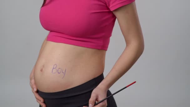 靠近点无法辨认的孕妇选择男婴性别的方法是在腹部画笔 站在白色背景上 — 图库视频影像