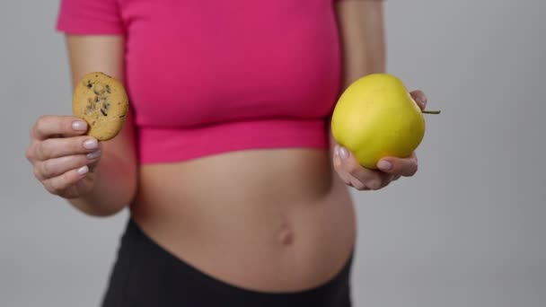 Zbliżenie Ciężarna Kobieta Trzyma Żółte Jabłko Jednej Ręce Ciasteczko Drugiej — Wideo stockowe
