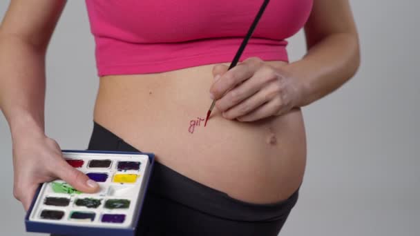 Close Pregnant Woman Paints Words Girl Her Belly Red Watercolor — Stock Video