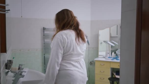 Langzame Beweging Een Vrouw Komt Badkamer Binnen Een Witte Badjas — Stockvideo
