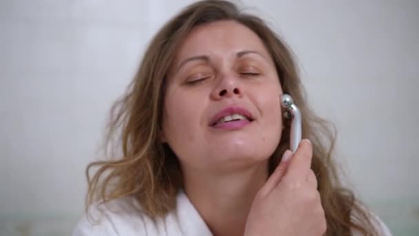 Zbliżenie Kobieta Białym Szlafroku Robi Sobie Masaż Twarzy Wałkiem Masażu — Wideo stockowe