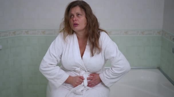 Kobieta Białym Szlafroku Siedząca Krawędzi Wanny Silny Ból Brzucha Kobieta — Wideo stockowe