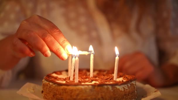 一个无法辨认的女人坐在餐桌旁 在生日蛋糕上点着蜡烛 — 图库视频影像