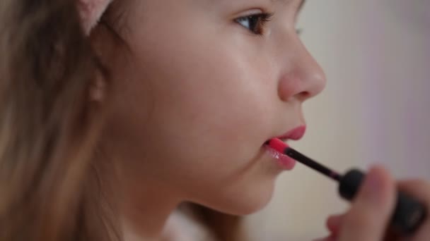 クローズアップ スローモーション 小さな女の子はブラシと笑顔で彼女の唇に明るい液体口紅を適用する — ストック動画