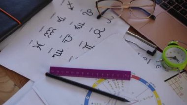 Yakın plan. Astrolojik aksesuarlarla dolu bir masa ve modern bir astrologun ofisinde bir laptop.