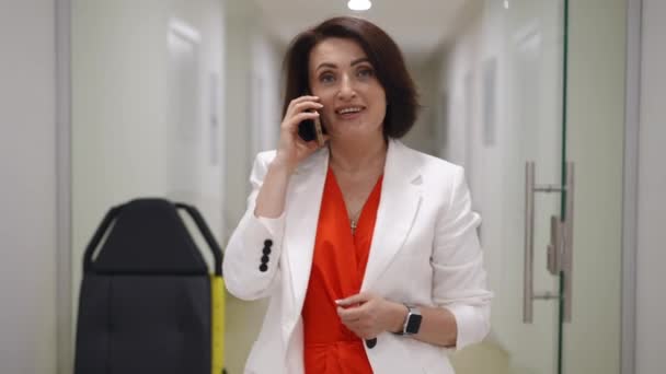 Eine Frau Weißer Jacke Spricht Mit Ihrem Handy Während Sie — Stockvideo