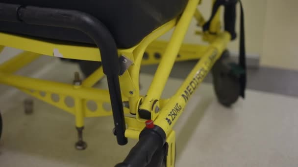 このビデオは 患者の移動椅子の黄色い金属フレームの詳細なクローズアップビューを示しています カメラは アームレスト 患者の移動椅子のフレームにズームし その強調 — ストック動画