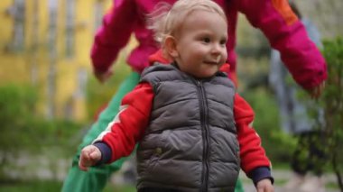 Ağır çekim. Çocuklar bir bahar günü bir yerleşim yerinin avlusunda bir park alanında mutlu bir şekilde oynarlar. Küçük bir oğlan ve genç bir kız çimlerin üzerinde gülüp oynuyorlar.