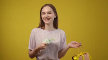 Neşeli ve enerjik bir kadın alışveriş malzemelerini neşeyle tutuyor, etrafa bulaşıcı neşe ve pozitiflik saçıyor.