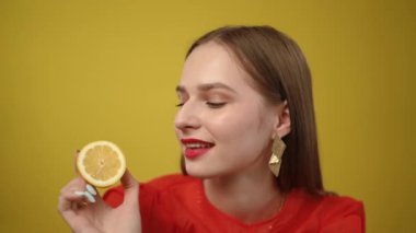 Şık bir genç kadın kendine güvenen parlak bir limonla poz veriyor, canlı renkler sergiliyor ve modern moda anlayışı