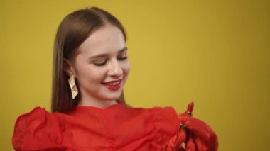 Bir model, parlak bir zemin karşısında modern moda eğilimlerini vurgulayan canlı kırmızı bir elbise sergiliyor..