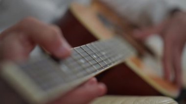 Sanatsal bir resim, akustik bir gitarı tıngırdatan, müziği ve yaratıcılığı vurgulayan elleri güzel bir şekilde resmeder.