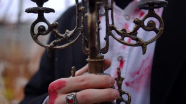 Kanlı ellerle tutulan süslü bir şamdanın akıldan çıkmayan görüntüsü büyüleyici bir gotik estetiği somutlaştırıyor.