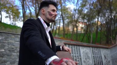 Şık takım elbiseli şık bir adam, doğal güzelliği zengin bir şekilde resmedilmiş açık havada düşünceli bir şekilde poz verir.
