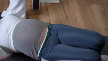 Rahatlamış hamile bir kadın, sakin bir iç mekanda yoga yapıyor, genel sağlık ve sağlığını destekliyor.