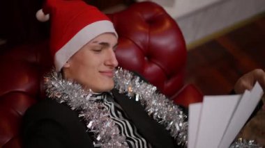 Hoş bir Noel Baba şapkası takan neşeli bir genç adam, neşeli bir tatil sezonunun tadını çıkarıyor.