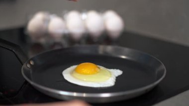 Bu, arka planda birkaç yumurta ile sıcak tavada mükemmel bir şekilde kızartılmış yumurta görüntüsü.
