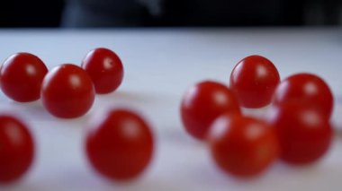 Canlı vişneli domatesler saf beyaz bir arka planda sanatsal ve güzel bir şekilde düzenlenir.
