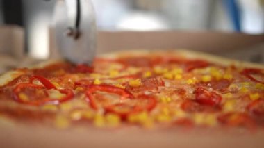 İşte ağız sulandıran, kırmızı biberli ve tatlı mısırlı lezzetli bir pizzanın yakından görüntüsü.