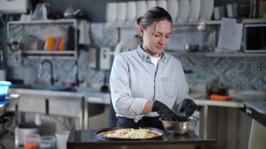 Canlı ve hareketli bir mutfak ortamında, çok yetenekli bir şef özenle lezzetli bir pizza yapar.