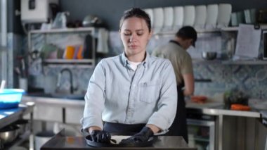 Çok iyi odaklanmış ve yetenekli bir şef modern mutfak ortamında taze malzemeler hazırlar.