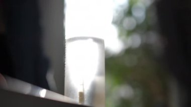 Bir el, şeffaf bir su şişesini ahşap kapakla kapatıyor. Görüntü, günlük rutinlerde su kaybına ve çevre dostu sağlık ürünlerinin kullanımına olan dikkati vurguluyor.