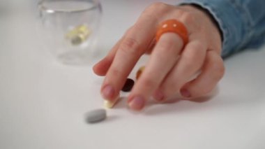 Çeşitli vitaminler, günlük sağlık rutininin bir parçası olarak cam kenarındaki bir masaya düzgünce yerleştirilmiştir. Bu görüntü, sağlıklı bir yaşam için takviyelerin önemini vurgular.